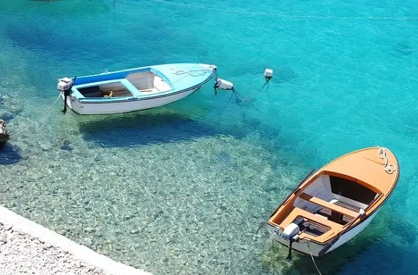 Two boats on a sunny day during on shore.